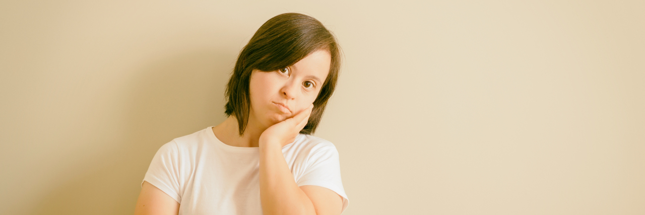 Why Down Syndrome Awareness Is Still So Important Thoughtful woman with Down syndrome.