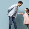 Father in a nice shirt and jeans dancing with his daughter in a pink dress