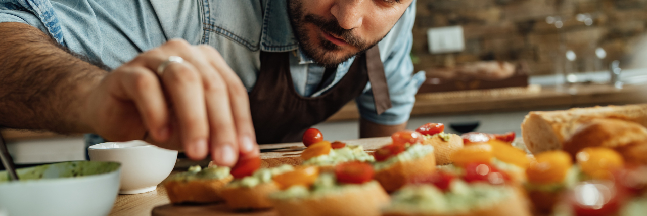 Why and How I Cook With a Seizure Disorder Man preparing bruschetta in the kitchen.