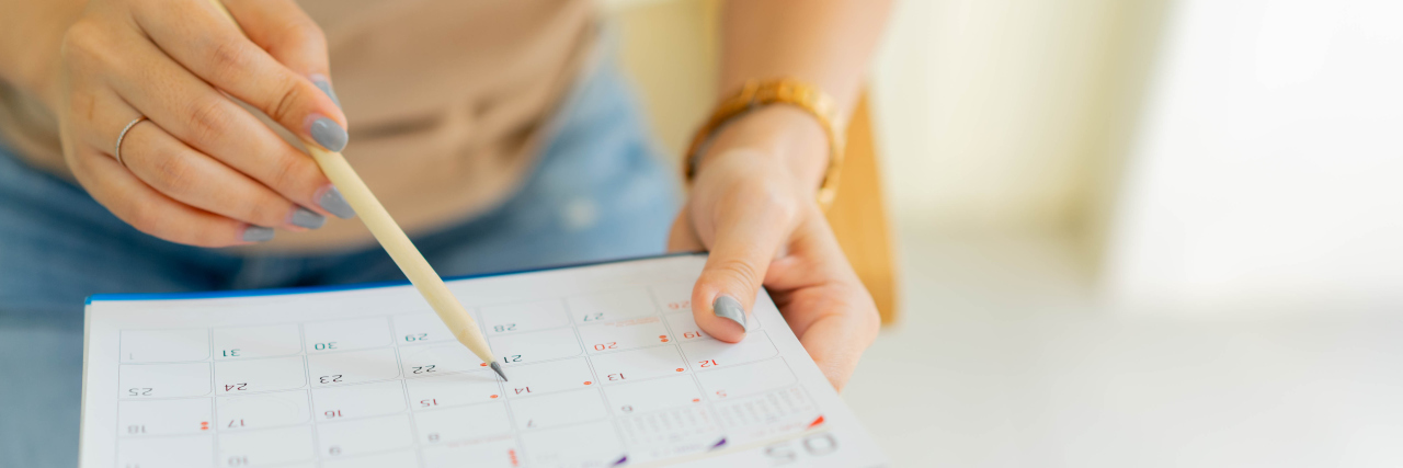 4 Tips for Coping With ADHD Woman marking dates on calendar.
