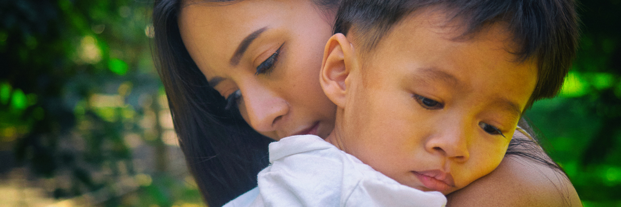 Processing Past Trauma as the Parent of a Child With a Rare Disease Sad son hugging his worried mother.