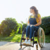 Young woman in wheelchair looking into the distance.