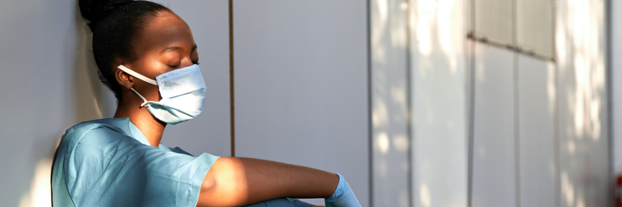 How the Nursing Shortage Affects Patients Exhausted female Black nurse wearing face mask.