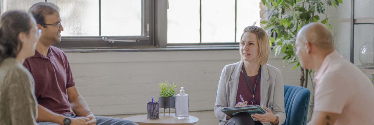I'm Thankful for a Positive Psych Ward Stay When I Was Suicidal A group of four middle aged adults sit in a circle in attendance to a therapy session in urban office space.