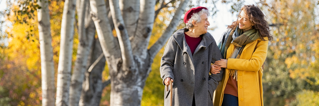 3 Ways to Support a Loved One With Multiple Sclerosis Daughter walking with senior woman in park.