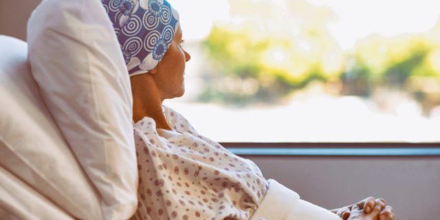 Young woman with cancer in hospital bed.