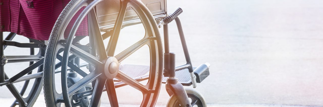 Empty wheelchair with pink seat.