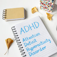 ADHD Attention Deficit Hyperactivity Disorder written in notebook on table.