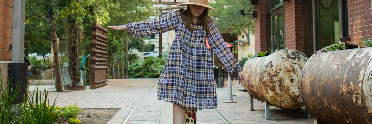 We Won't Put a Trigger Warning on Our Daughter With a Disability Callie walking down a street. Her prosthetic limb is visible.