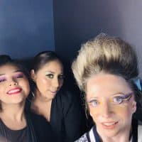 Contributor with hair and makeup done and posing with others at fashion show
