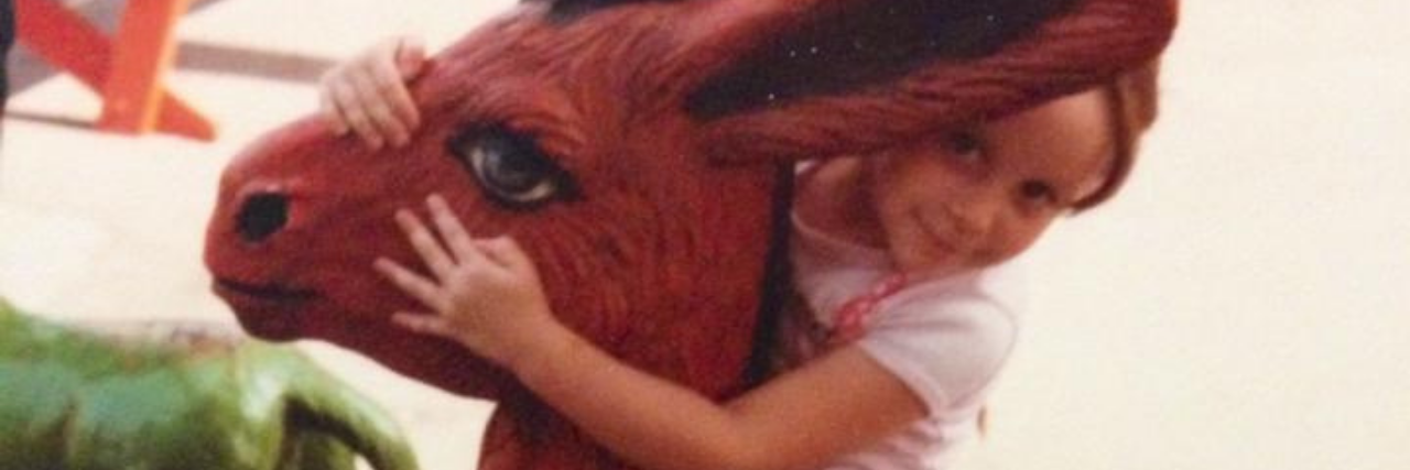 What Happens When My Inner Child Is Triggered in Trauma Therapy photo of the contributor as a child, sitting on a donkey statue and smiling