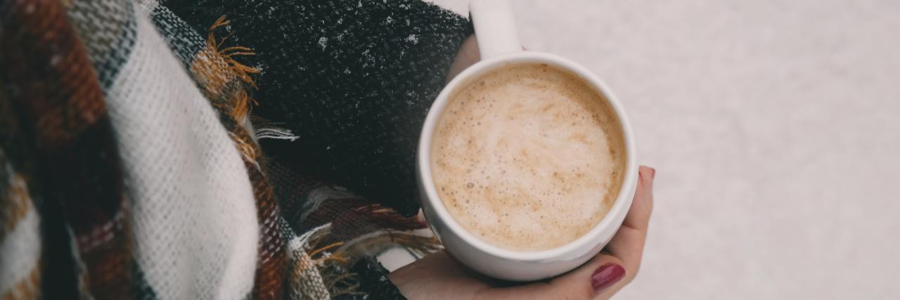 Woman holding a cup of hot cocoa.