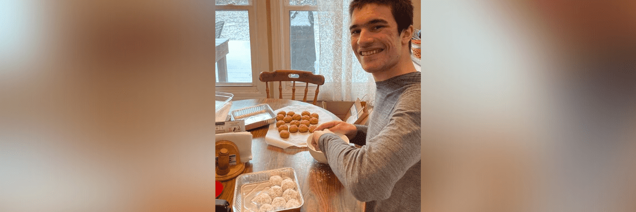 My Son With Autism Found Success and Community Opening a Business Dominic at the kitchen table smiling and making baked goods
