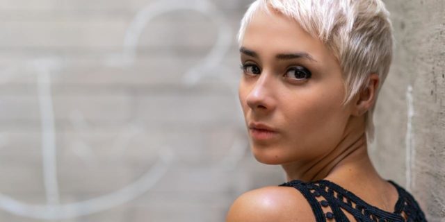 I Lost My Identity As the ‘Good Daughter’ When I Dared Prioritize Myself photo of a woman with short hair looking over her shoulder into camera