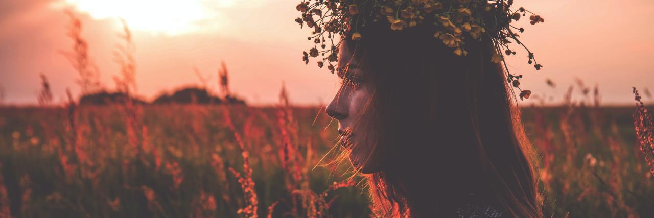 photo of a woman at sunset in a field wearing a flower headdress
