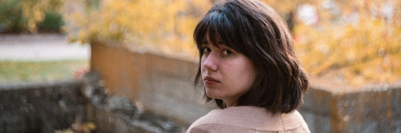 Advice If You Were Sexually Assaulted on Halloween photo of a woman during fall looking back over shoulder with sad or serious expression