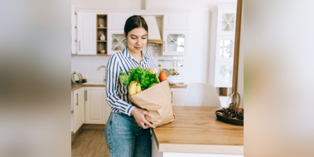 How Nutrition Can Make or Break Early Addiction Recovery Woman holding brown bag full of fresh vegetables in kitchen