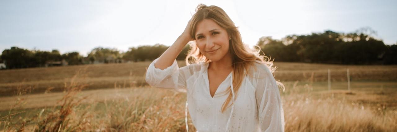 Living With and Treating an Articulation Speech Disorder Woman standing in field backlit by sun
