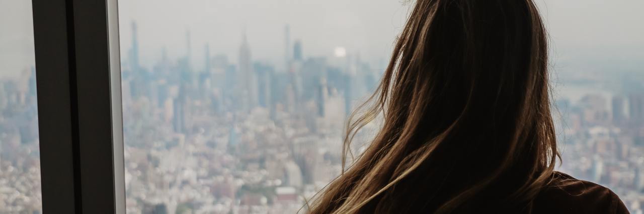 photo of a woman from behind looking out over New York City