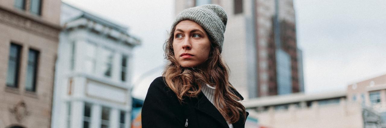 How Social Anxiety Impairs Some Life Skills, but Strengthens Others Woman in a winter hat standing outside a building, looking over her shoulder