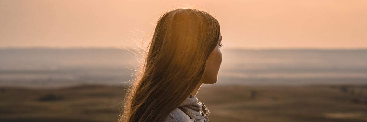 What I've Learned Living With Avoidant Restrictive Food Intake Disorder  Woman looking out over open vista a sunset