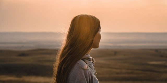 What I've Learned Living With Avoidant Restrictive Food Intake Disorder  Woman looking out over open vista a sunset