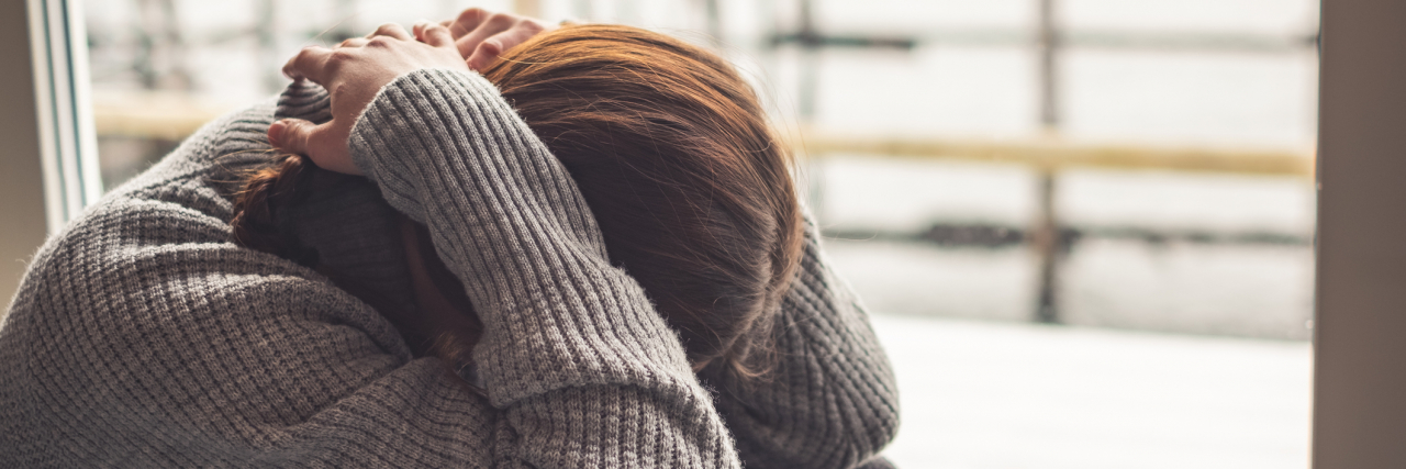 When Bipolar Disorder Makes Even the 'Simple' Things Hard Woman with her head in her knees, hands covering her face, stressed