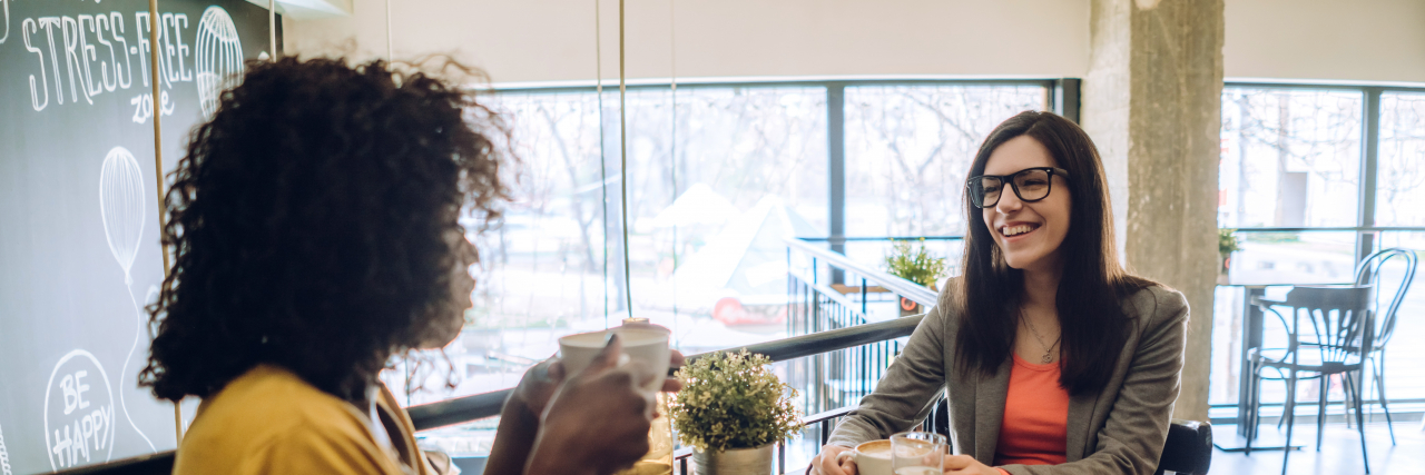 How to Respond When a Friend Tells You They’re Autistic Women drinking coffee in cafe.