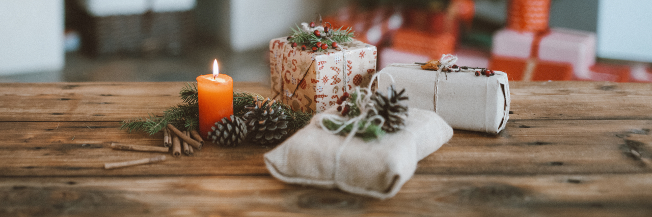 3 Tips for Coping With Inflammatory Bowel Disease During the Holidays Holiday gifts and candle on table.