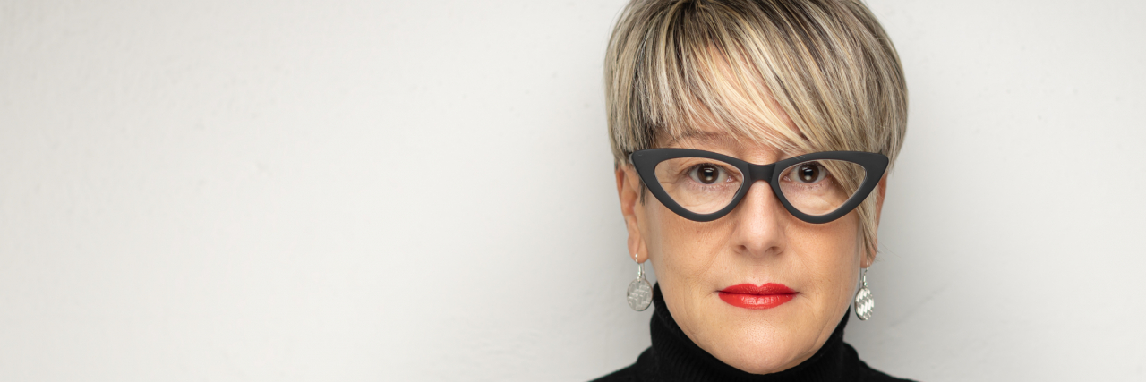 I'm Not a Failure Because of How I Coped With Bipolar Mania Middle-aged woman with short, white hair and glasses looking into the camera seriously