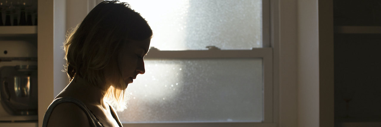 Silhouette of young woman holding her phone