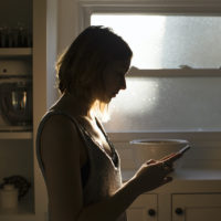 Silhouette of young woman holding her phone