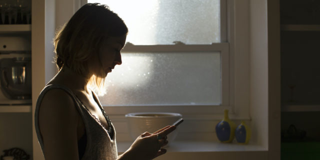 What It's Like to Be Infertile When You Have Rare Disease  Silhouette of young woman holding her phone