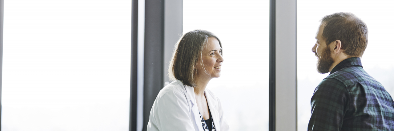 Why Documenting Stuttering in Medical Records Is Important Female doctor in discussion with male patient in exam room.
