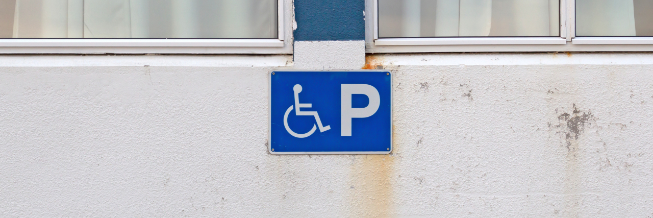 Why Getting a Disability Parking Pass Made Me Feel Conflicted Blue disability parking sign for disabled drivers.
