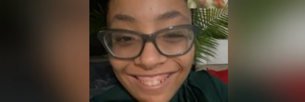 Author, a young Black woman with glasses smiling while on Facetime with her boyfriend
