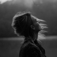 Black and white photo of profile of woman with wind blowing her hair
