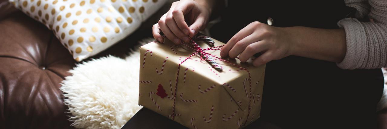Giving a Holiday Gift to Your Therapist? Keep These 5 Things in Mind Young woman sitting down with a gift wrapped in brown paper