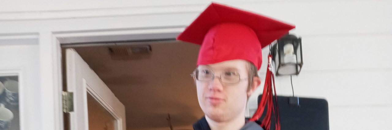 Celebrating My Son With Down Syndrome as He Finishes School AJ trying on cap and gown.