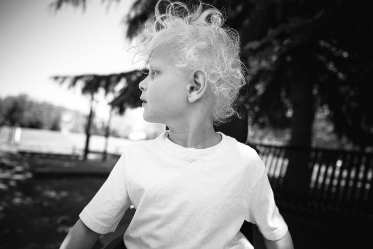 The author's son at 5 years old. Hew has curly blonde hair and is wearing a white T-shirt while looking to the side.