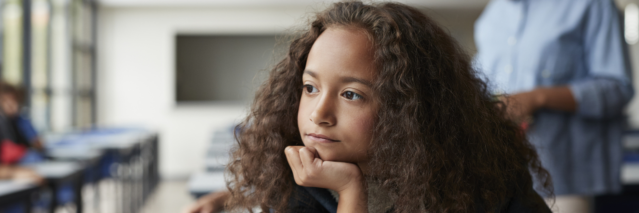 How the Special Education System Fails Students With Disabilities Lonely girl in school classroom.