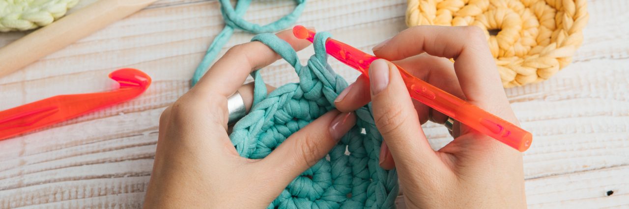 Top view of a woman's hands crocheting