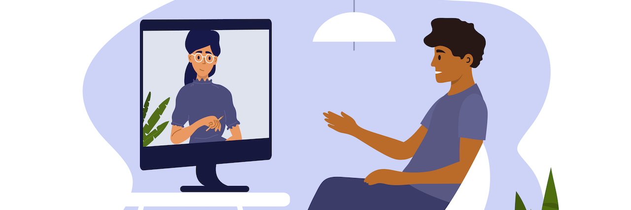 Man sitting on chair at home and talking to therapist on computer screen.