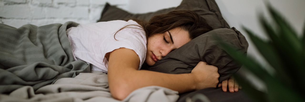 The Daily Struggle of Getting Out of Bed With Bipolar Disorder Young woman getting up early in the morning