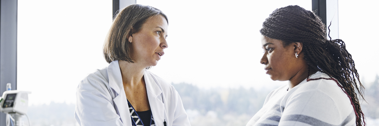 It's OK to Have Complicated Feelings About Your Cancer Being in Remission Doctor talking to femake patient.