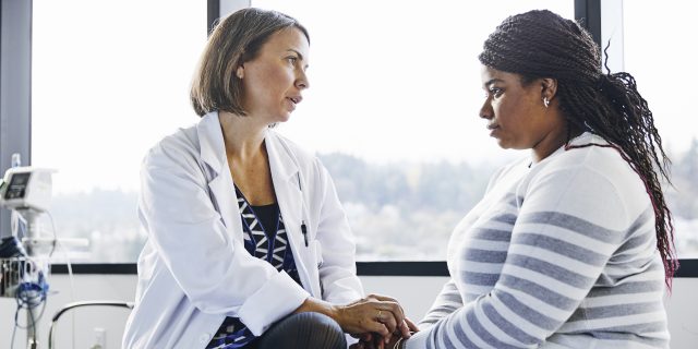 It's OK to Have Complicated Feelings About Your Cancer Being in Remission Doctor talking to femake patient.