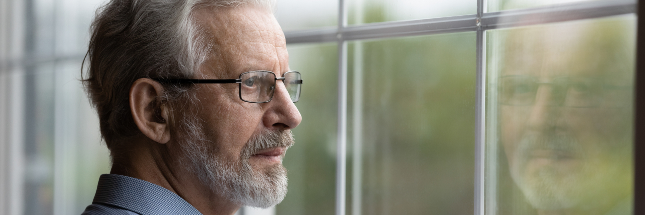 Please Don't Assume My Bad Days Are Always Because of Chronic Illness Thoughtful older man looking out window.