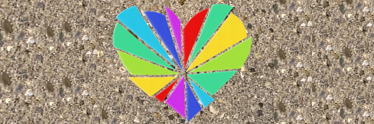 A colorful broken heart on brown gravel