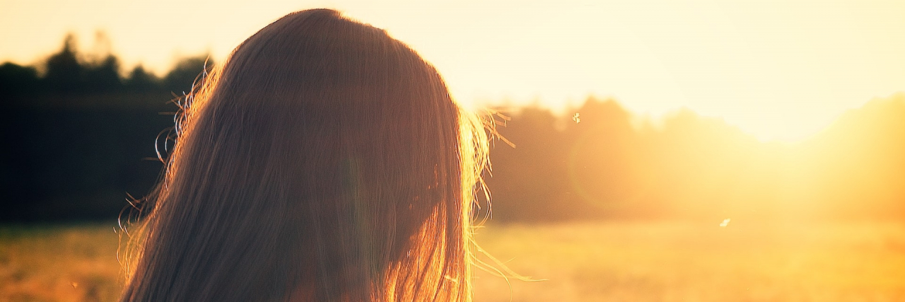 Surprise! That Bump You Didn’t Notice Is Thyroid Cancer Woman in a field at sunset.