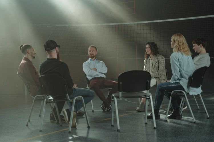 Group therapy, people sitting in a circle talking